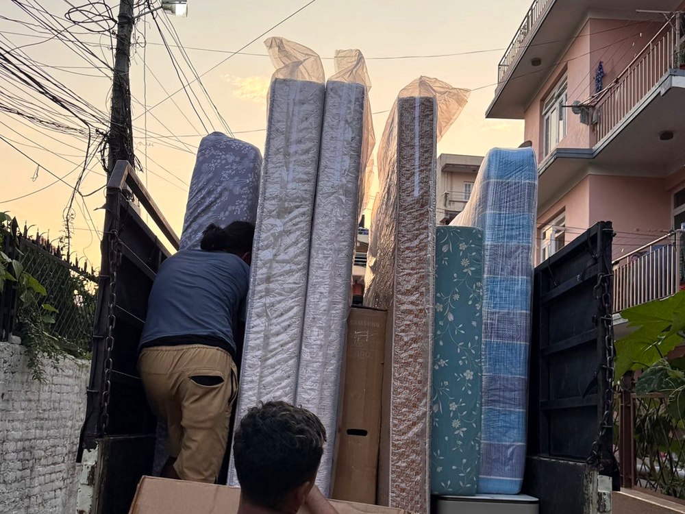Workers loading mattresses onto a moving truck