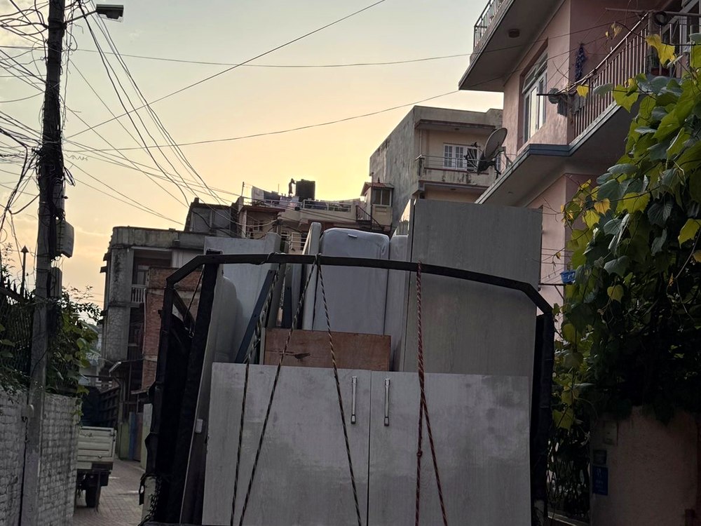 Furniture being loaded onto moving truck in narrow alley
