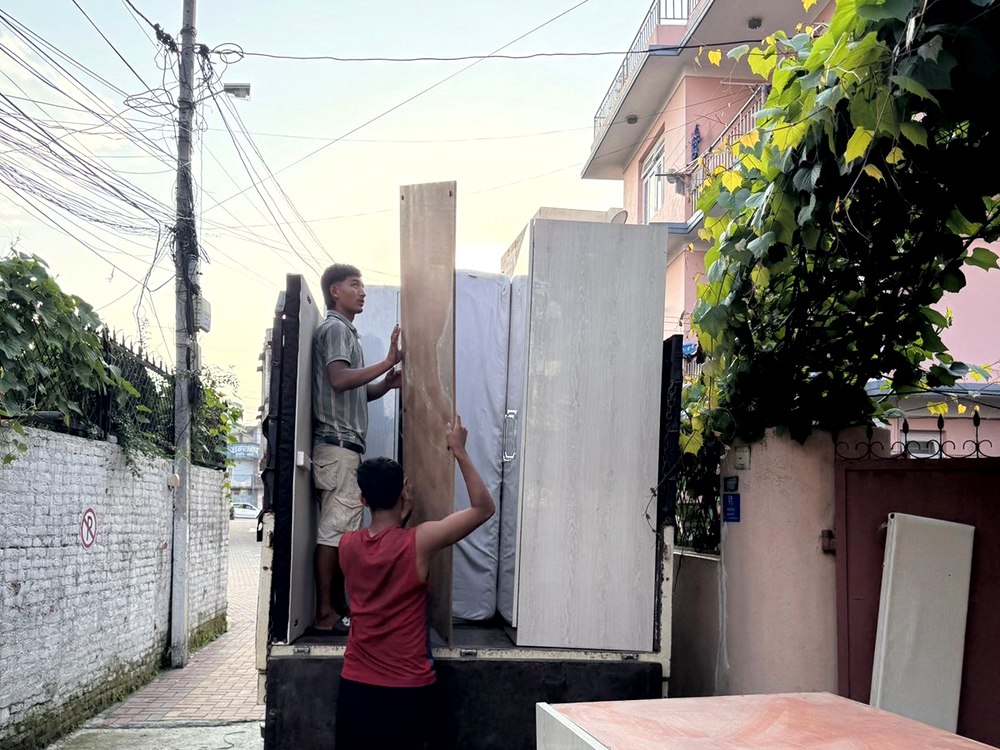 Workers loading wardrobe panels onto truck