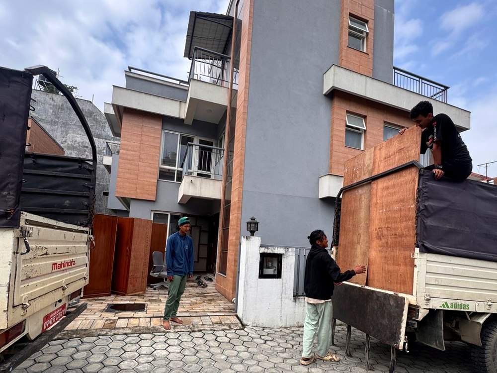 Office shifting team loading furniture outside a modern building